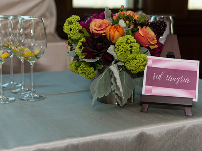 A table with flowers, wine glasses, and a sign that reads 'red sangria'.