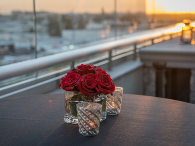 Closeup of a beautiful red flower and votive candles on The Terrace.