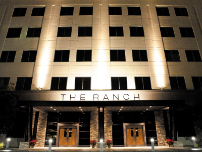 Brightly lit entry doors to The RANCH as seen at night.