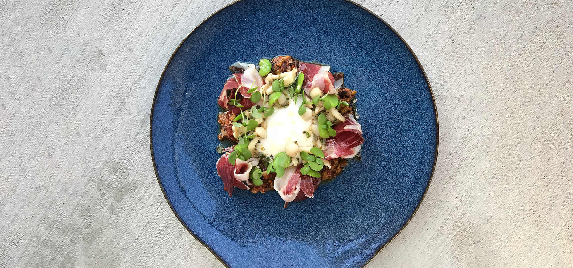 Mother's Day dish showing a dollop of mozzarella cheese with ham, olives, mushrooms, and fava beans