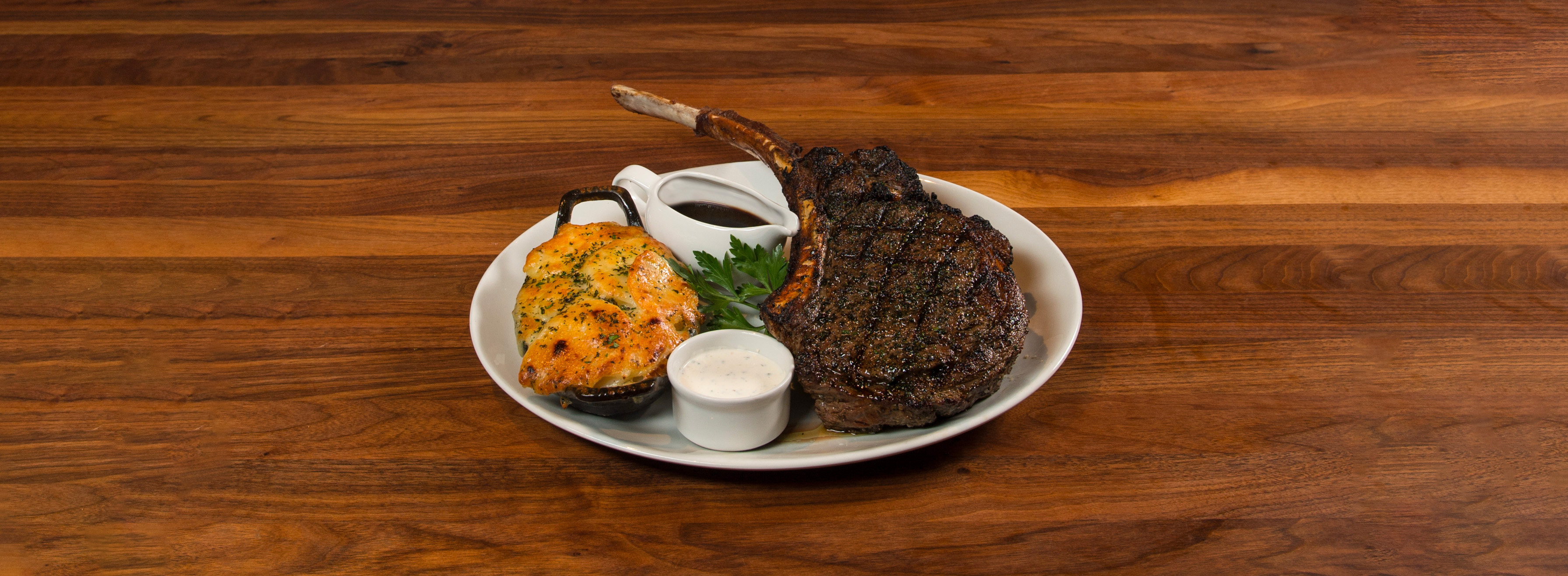 Dinner plate with large steak and baked scalloped potatoes