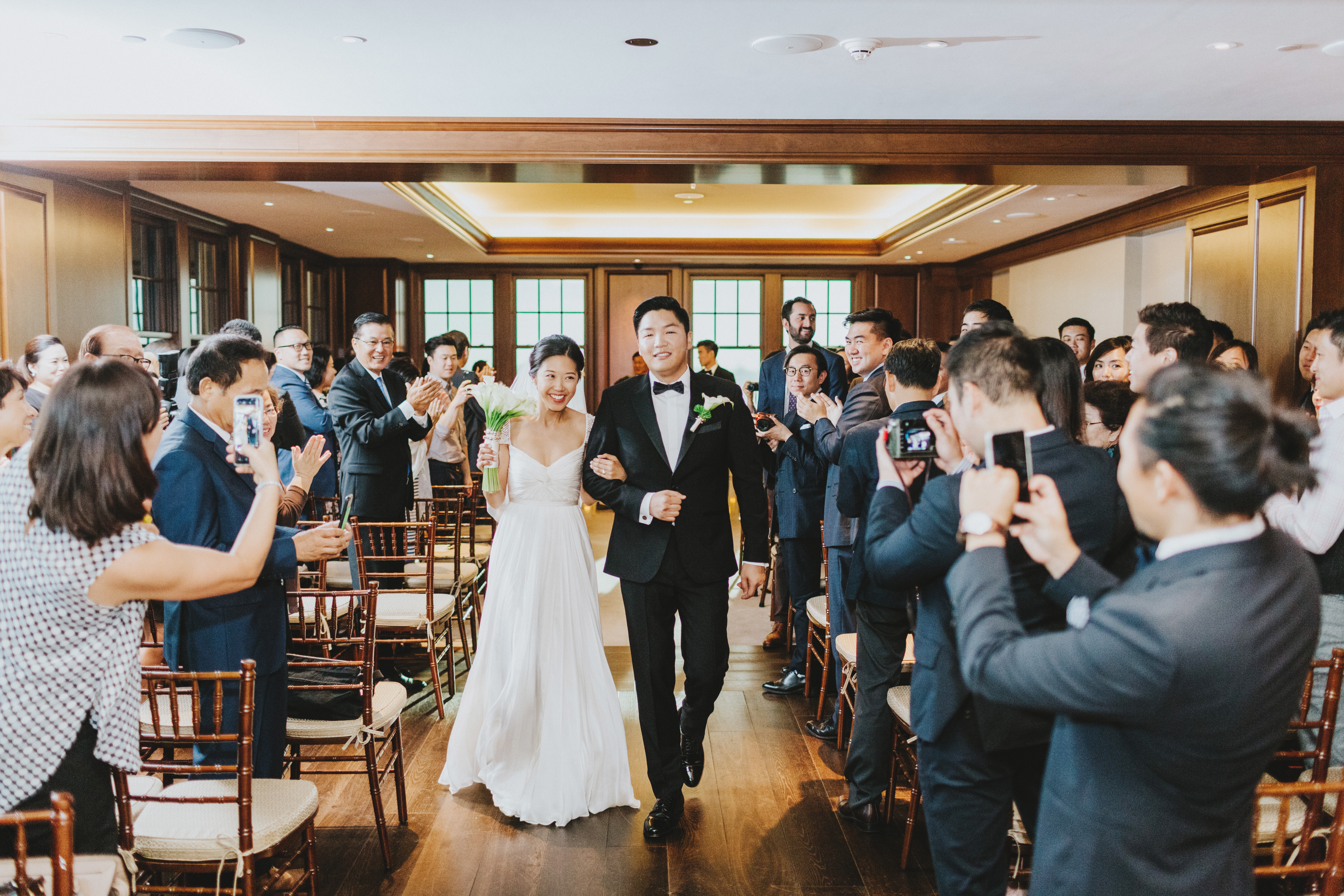 People celebrating a newlywed couple walking down the aisle