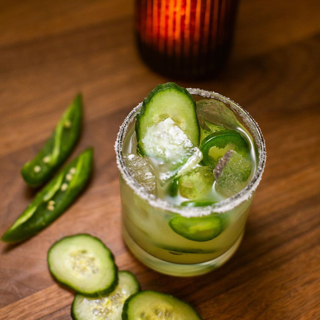 A green cocktail with cucumbers and jalapeños.