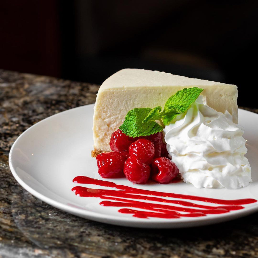 The New York Style Cheesecake with raspberries, raspberry sauce and whipped cream.