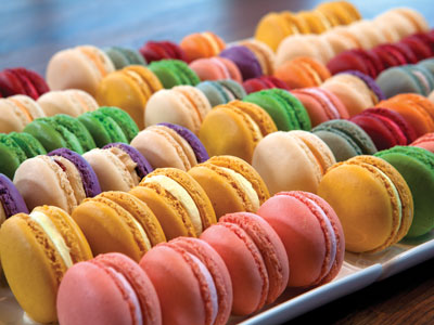 A tray of colorful desserts on a wood table.