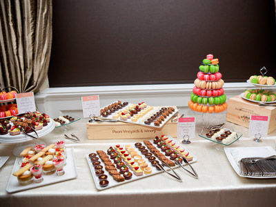 Table filled with an assortment of sweet treats, including candies, pastries, and a colorful Buche de Noel.