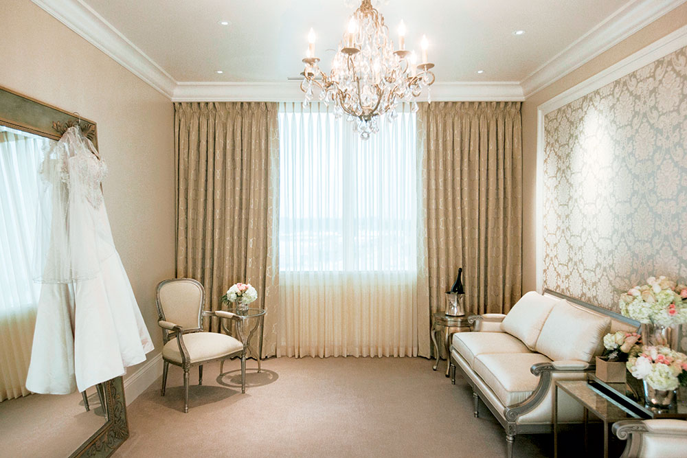 The Bridal Suite, with lounge seating and a wedding dress hanging by the mirror.
