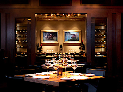 A row of wooden tables that look into a private dining room.