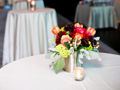 A round table with flowers and a candle on it.