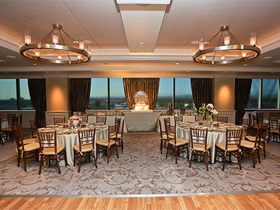 The Great Room set up with dining tables and flowers, a buffet table with an ice sculpture.