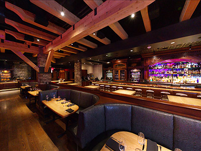 Inside the Ranch Saloon showing booth seating, tables and chairs, and 2 bars.