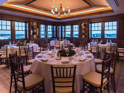 The Study wtih tables set for Xmas dinner, with holly and pointsettia wreath centerpieces.